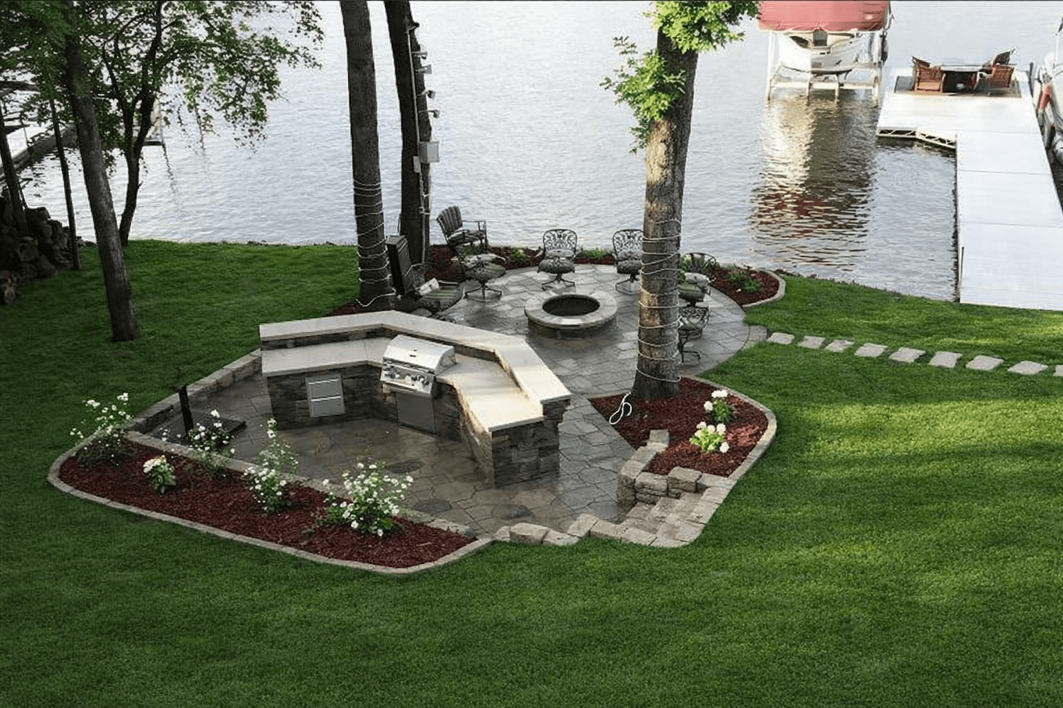 Custom outdoor kitchen with built-in grill and stone seating area in Lake Delton, WI