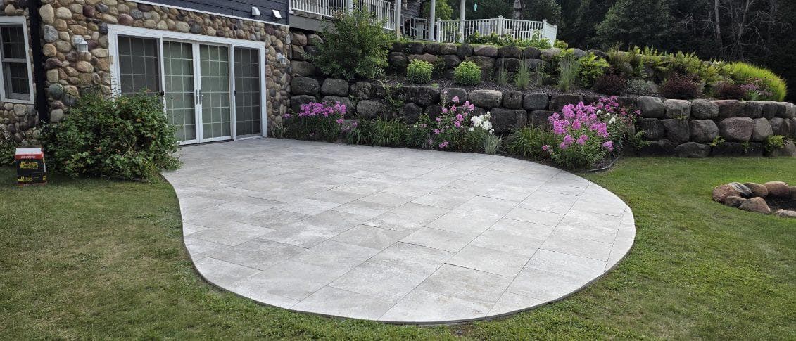 Paver patio installation with natural stone retaining wall in Oxford, WI