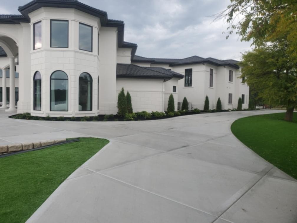 Arborvitae foundation plantings with dark mulch beds and ornamental shrub borders at estate home in Wisconsin Dells