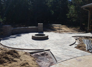 Patio, outdoor lighting, pillars, stone caps, fire pit, sod and plantings